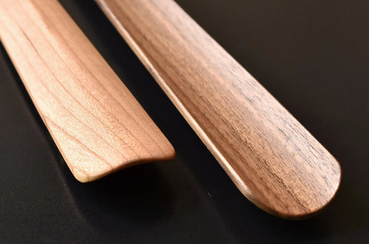 Wooden shoehorn with a multi-faceted handle and a smooth curved tip for easy slipping.